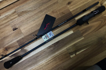 A pair of fishing rods on top of a wooden floor.